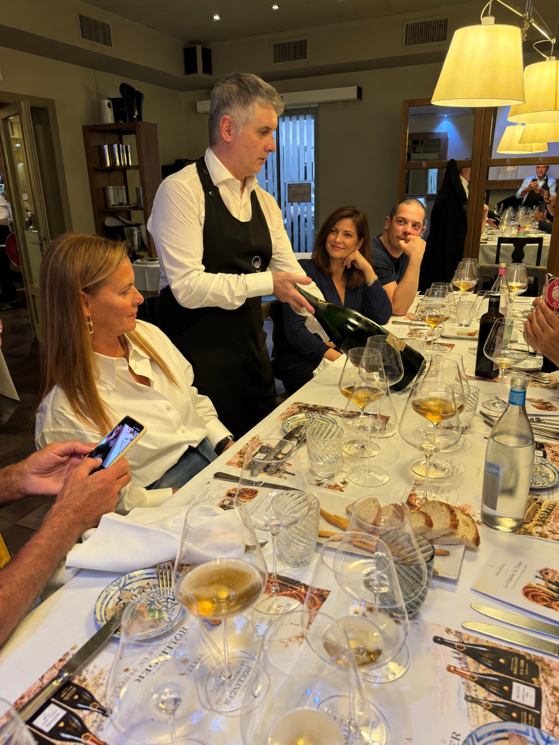 Dante serving the wines, with close attention to the table.
