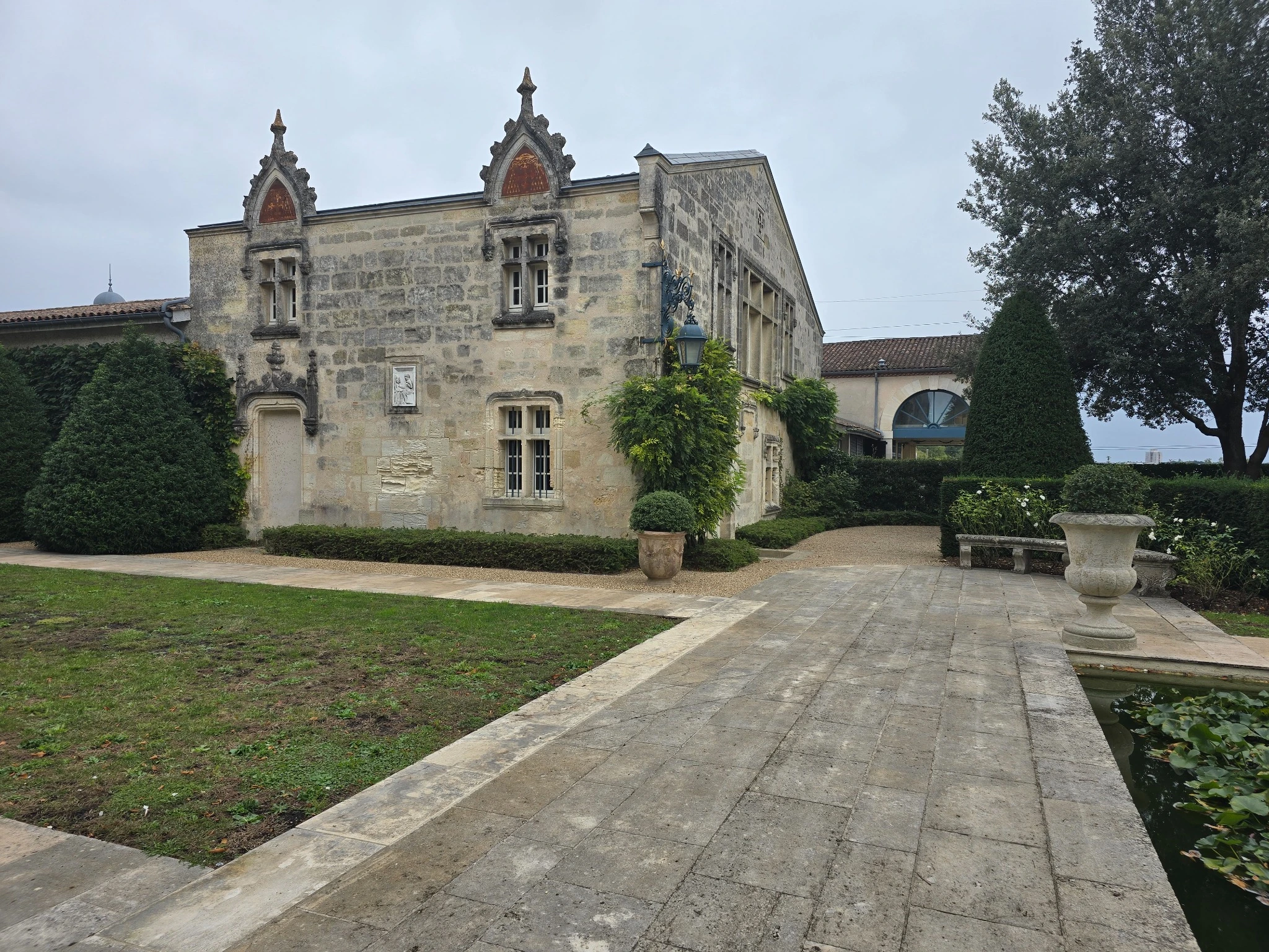 The historic façade of La Mission Haut-Brion, with an iron lantern and garden pool