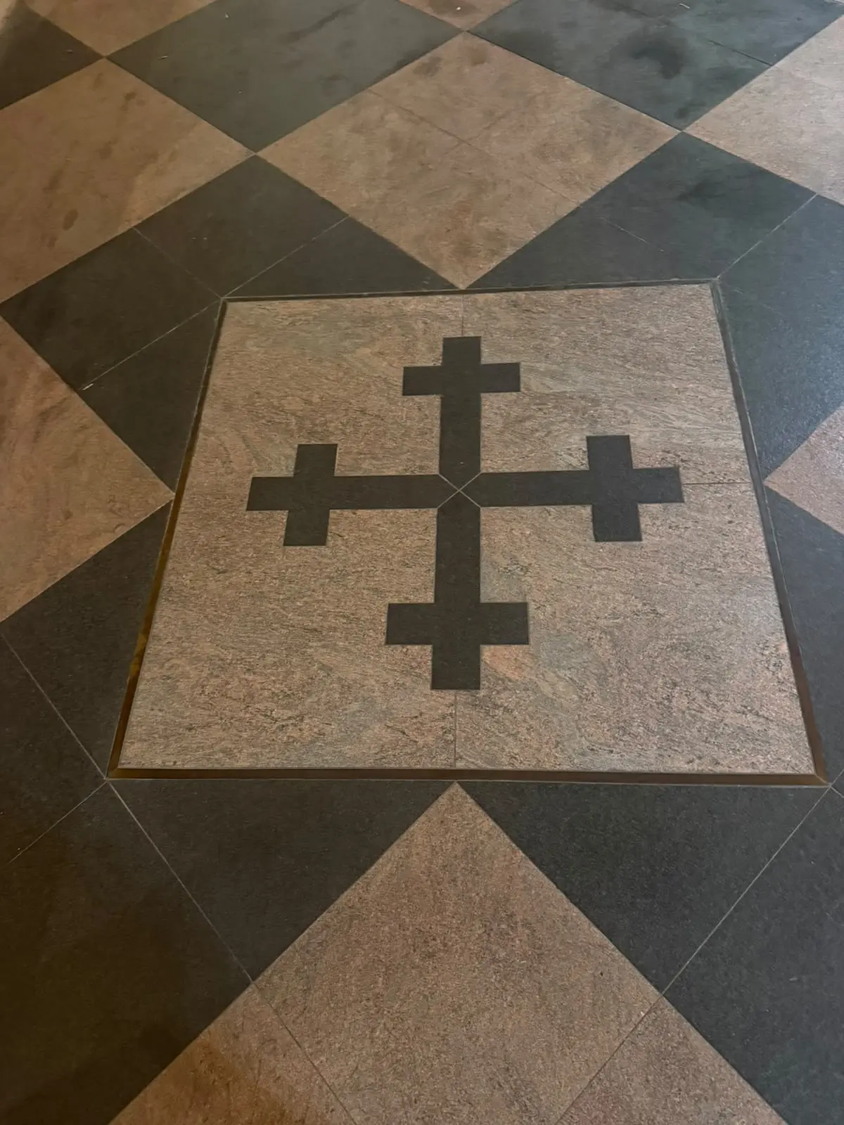 A cross emblem set into the cellar floor