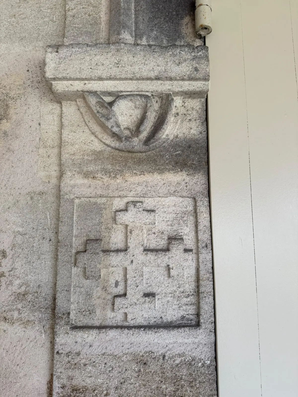A cross emblem carved in stone at La Mission Haut-Brion